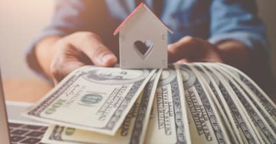 house wooden and banknote us dollar bills in hand ,Property investment and mortgage financial concept.