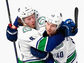 Brock Boeser, left, knows what linemate Elias Pettersson is putting up with in his resistance to the contract extension.