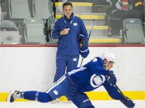 Calgary Flames forward Mikael Backlund, left, checks Vancouver Canucks defender Travis Hamonic in the foreground at Rogers Arena.