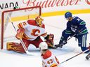 Calgary Flames goalkeeper Adam Werner (35) stops Alex Chiasson (39) of the Vancouver Canucks during the first period of an NHL preseason hockey game in Abbotsford on Monday.