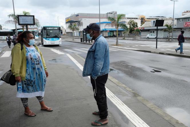 People wait for their bus in the almost deserted city center of Noumea, in the French Pacific territory of New Caledonia, on September 7, 2021. New Caledonia has imposed a new lockdown linked to Covid-19 from the 7th September 2021, after three new cases were confirmed in this French territory in the South Pacific which had been declared 