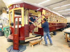 In this September 2019 file photo, RM Restorations technicians Serge Legare, left, and Jamie Bourdeau install cherry wood sliding doors on tram No.  351 Windsor as the restoration project nears completion.