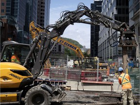 Crews use a jackhammer to install I-beams as the REM rail project and the Ste-Catherine St. redevelopment project collide at the intersection in Montreal on July 16, 2020.