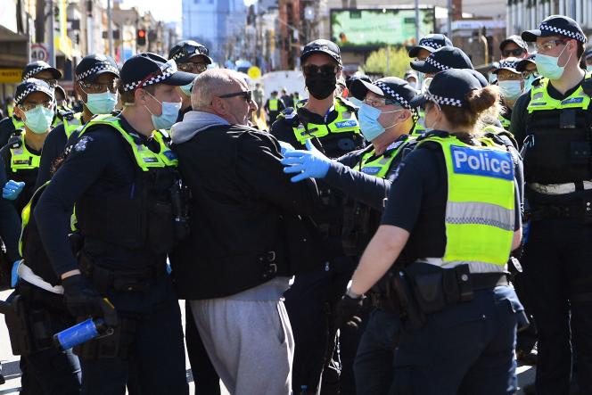 Police detain a protester Saturday, September 18, in Melbourne, Australia.