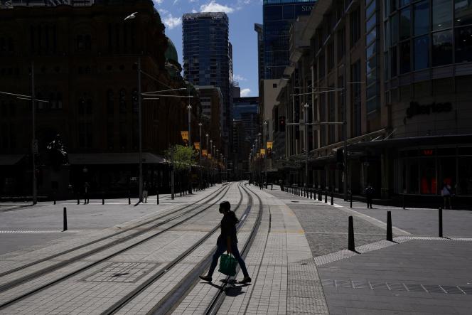A pedestrian crosses an empty street of passers-by in the confined city of Sydney on September 24, 2021.