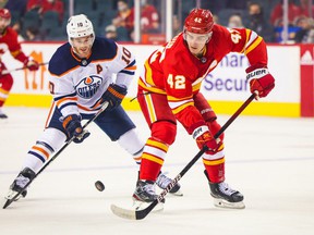 Calgary Flames center Glenn Gawdin (42) and Edmonton Oilers center Derek Ryan (10) battle for the puck during the first period at Scotiabank Saddledome.
