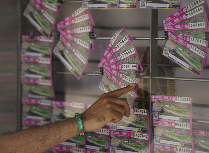 A customer indicates the lottery ticket he wants to buy, in an attempt to win one of the drug lords' possessions, put at stake by the Mexican government, in Mexico City, September 13, 2021.
