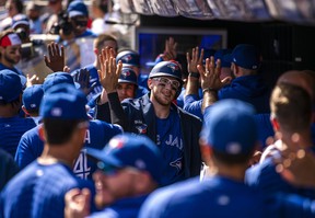 The Blue Jays' Danny Jansen celebrates with his teammates while wearing the blue Home Run jacket after hitting a three-run home run in the second inning against the Minnesota Twins at Target Field on September 26, 2021 in Minneapolis.  Stephen Maturen / Getty Images