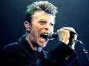 British pop star David Bowie yells into the microphone as he performs on stage during his concert in Vienna, on February 4, 1996. 