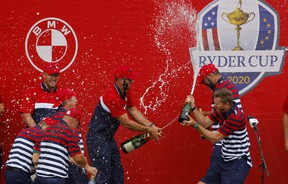 Team USA's Dustin Johnson sprays his teammates champagne as they celebrate after winning the Ryder Cup against Team Europe.