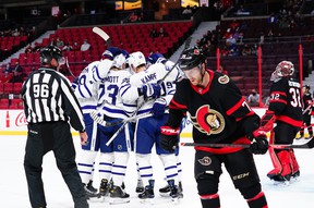 Maple Leafs players celebrate a goal by Leafs center David Kampf as Senators center Chris Tierney skates during first-period preseason action in Ottawa on Wednesday, Sept. 29, 2021.