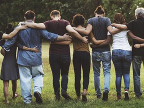 Group of friends huddle together in rear view