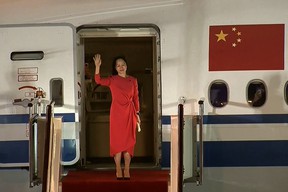 This screenshot from video posted by Chinese state broadcaster CCTV shows Huawei executive Meng Wanzhou waving as she exits the plane upon arrival after its release in Shenzhen, Guangdong province. , in southern China, on September 25, 2021.