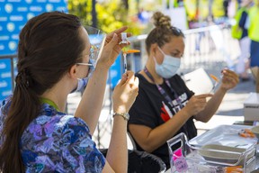 Vancouver Coastal Health nurses work on a vaccination pop-up in Playland as health officials push to increase the number of fully vaccinated adults in British Columbia.