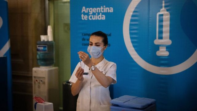 A woman prepares a vaccine in Argentina.