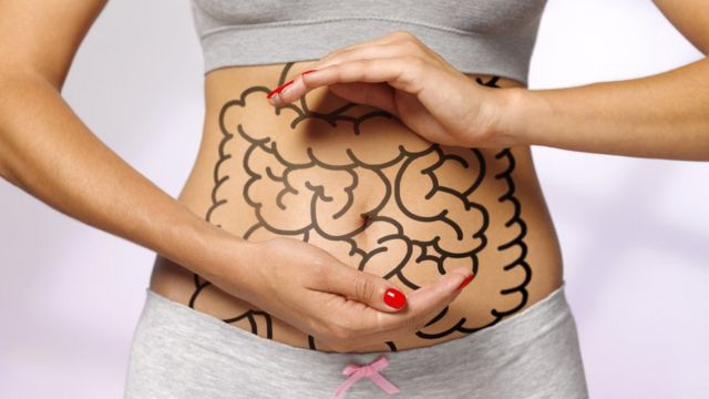 Woman with digestive system drawn on the body.