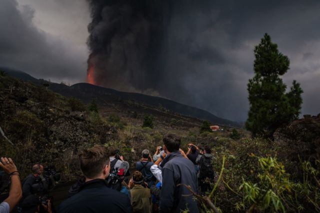 Citizens on a hillside observe the eruption of the Cumbre Vieja volcano