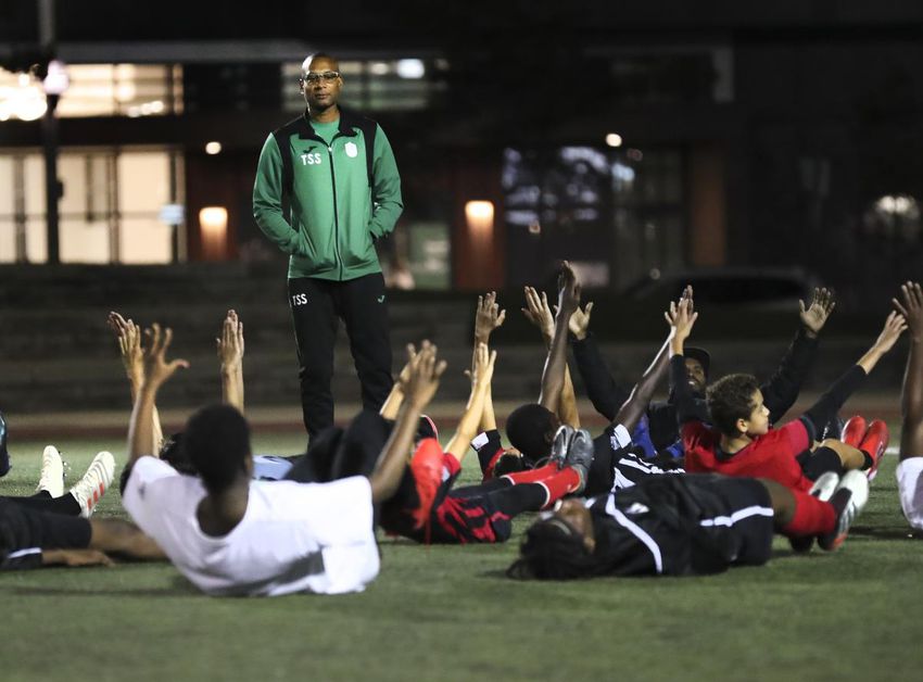 Coach T'ai Simm-Smith conducts some stretching exercises after a youth practice soccer game at Regent Park.  As the neighborhood grapples with the shooting death of beloved youth worker Thane Murray, many in the community are concerned about the impacts of gun violence on the neighborhood's younger residents.