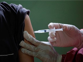 A patient is vaccinated against COVID-19.
