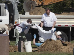 The individuals are displayed at Lakeview Cemetery in Leamington on Wednesday, Sept. 29, 2021, where a body is exhumed from a decades-old grave.