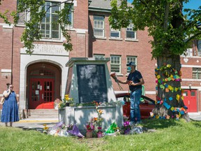 People lay flowers in front of the administration building at Kamloops' former Indian residential school, after the remains of 215 children, some as young as three, were found there.