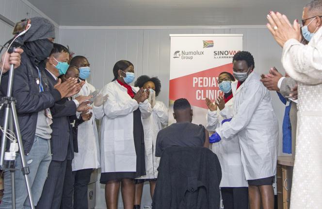 People applaud after a dose of Sinovac's CoronaVac vaccine is given to a teenager in Pretoria, South Africa on September 10, 2021.