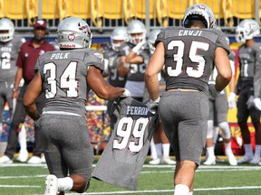 Gee-Gees Amlicar Polk and Braeden Cruji wear Francis Perron's jersey off the field at Richardson Stadium in Kingston on Saturday.