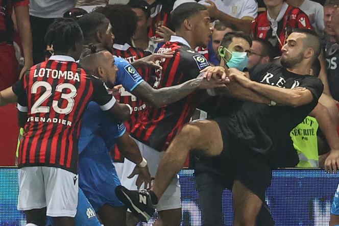 Marseille midfielder Dimitri Payet (2nd from left), as players from OGC Nice and Olympique de Marseille prevent the supporter from invading the pitch during the football match on August 22, 2021.