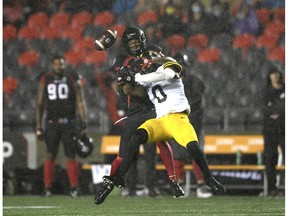 Hamilton Tiger-Cats defensive back Ciante Evans (0) tackles the ball destined for Ottawa Redblacks slotback Kenny Stafford (85) during the first half of CFL football action in Ottawa on Wednesday, April 22. September 2021.