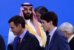 Saudi Crown Prince Mohammed Bin Salman looks up at Justin Trudeau