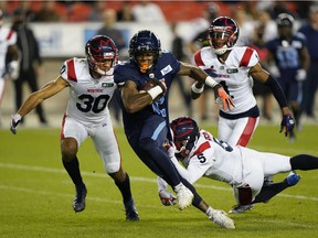 Toronto Argonauts wide receiver Ricky Collins Jr. (2) tries to break tackles from Ty Cranston (30) and Montreal Alouettes' Greg Reid (5) after a pass reception during the first half at BMO Field in Toronto on Friday, September 24.  , 2021.