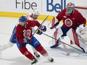 Canadiens' Xavier Oullet, left, fights Ryan Poehling against goalie Cayden Primeau during training camp Thursday in Brossard.