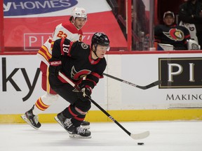 Ottawa Senators left wing Tim Stuetzle skates the puck off Calgary Flames center Sean Monahan in the first period at the Canadian Tire Center on March 22, 2021.