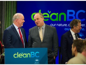 BC Prime Minister John Horgan (left) and former BC Green Party leader Andrew Weaver come together at the Vancouver Public Library in Vancouver, BC on December 5, 2018.