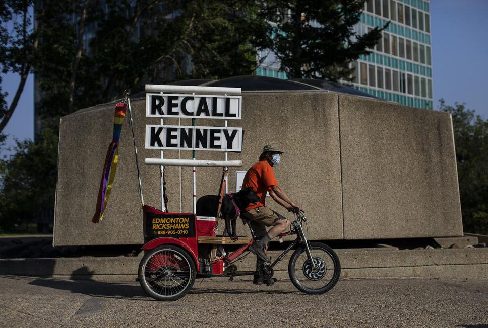 David Williamson travels with a Recall Kenney sign during a protest in support of the COVID-19 health orders, calling on the province to reinstate restrictions such as mandatory isolation in Edmonton on August 4.