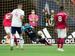 Vancouver Whitecaps' Brian White, right forward, scores against FC Dallas goalkeeper Jimmy Maurer, back, as Justin Che defends during the first half of an MLS soccer game in Vancouver on Saturday, Sept. 25, 2021.