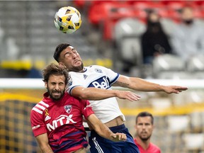 Facundo Quignon of FC Dallas, left, and Lucas Cavallini of Vancouver Whitecaps compete for the ball during the first half of an MLS soccer game in Vancouver, Saturday, Sept. 25, 2021.