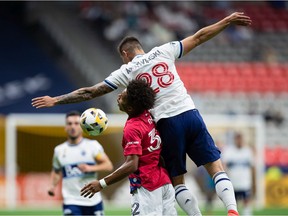 Justin Che (32) of FC Dallas and Jake Nerwinski (28) of Vancouver Whitecaps compete for the ball during the first half of an MLS soccer game in Vancouver on Saturday, Sept. 25, 2021.