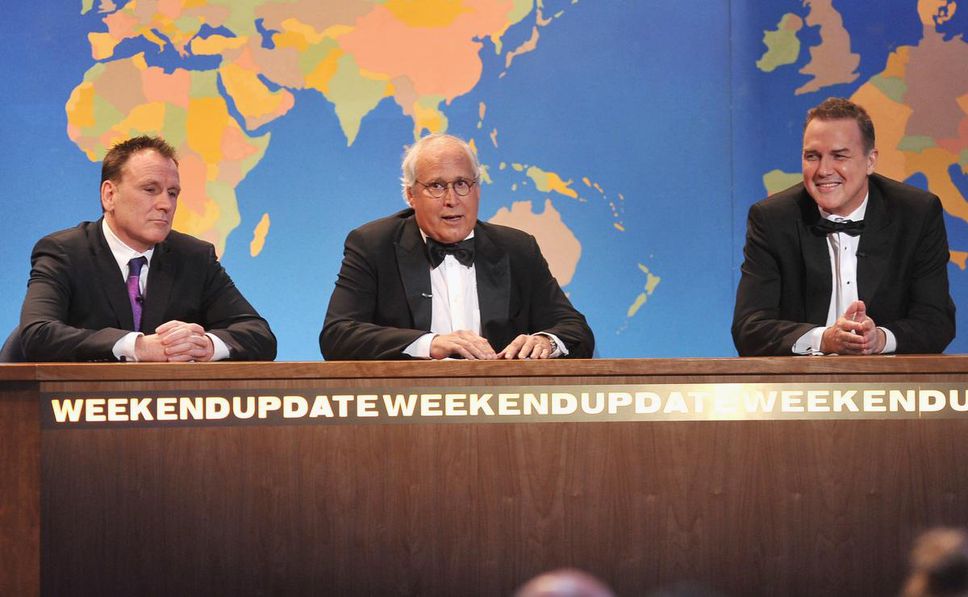 One of his most popular roles in "SNL" he was hosting the Weekend Update, a satirical version of the weekly news.  He appears here on the set of SNL in a 2012 segment of The Comedy Awards with Colin Quinn and Chevy Chase.