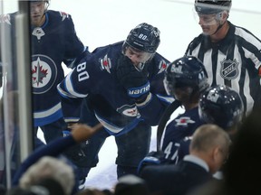 Winnipeg Jets center Pierre-Luc Dubois (center) heads to the locker room after receiving a mouth check from Ottawa Senators forward Ridly Greig during the NHL exhibition game at the Canada Life Center in Winnipeg on Sunday, Sept. 26, 2021.