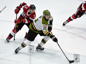 Brandon Coe of the North Bay Battalion skates against Teddy Sawyer and Adam Varga of the Ottawa 67 in the teams' Ontario Hockey League game at TD Place on February 9, 2020.