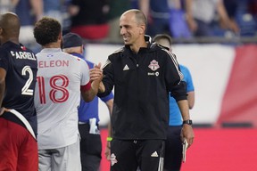 Toronto FC interim coach Javier Pérez (right) is congratulated by midfielder Nick DeLeon after defeating the New England Revolution.