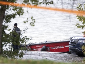 Montreal Police investigate the scene Monday, Oct. 18, 2021, after firefighter Pierre Lacroix was killed during a rescue operation in Lachine Rapids.