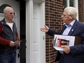 Kirkland incumbent Mayor Michel Gibson (right) speaks with resident Gary Bowman while campaigning door-to-door.