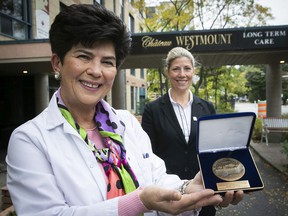 Zara Pilian, general manager of Château Westmount, holds the National Assembly Medal presented to the establishment on Friday, October 22, 2021 by MNA Jennifer Maccarone, background, for her 