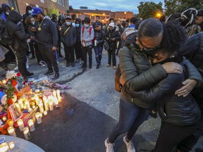 Women hug at a vigil for Jannai Dopwell-Bailey in Montreal on Friday, Oct. 22, 2021.