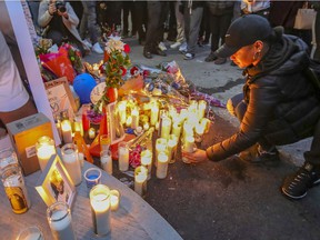 A woman places a candle at a vigil for Jannai Dopwell-Bailey in Montreal on Friday, Oct. 22, 2021.