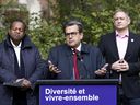 Denis Coderre, candidate for mayor of Montreal, speaks as Gabriel Retta, candidate for city councilor of Cote-Des-Neiges-Notre-Dame-De-Grace Loyola, left, and Daniel Vaudrin, candidate for councilor of Ville-Marie Sainte-Marie municipality, look at Sunday October 24, 2021.
