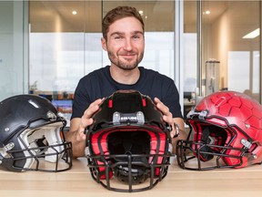 Franck Le Navéaux with a final prototype of a Kollide football helmet, flanked by older versions.  He is the research coordinator for the Kollide consortium of four Montreal companies that designed the helmet.