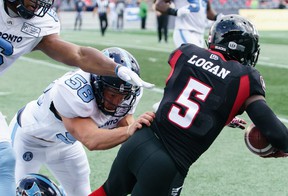 Stefan Logan # 5 of the Ottawa Redblacks is pushed out of bounds by Nakas Onyeka (# 6) and Jake Reinhart (# 58) of the Toronto Argonauts in 2019.